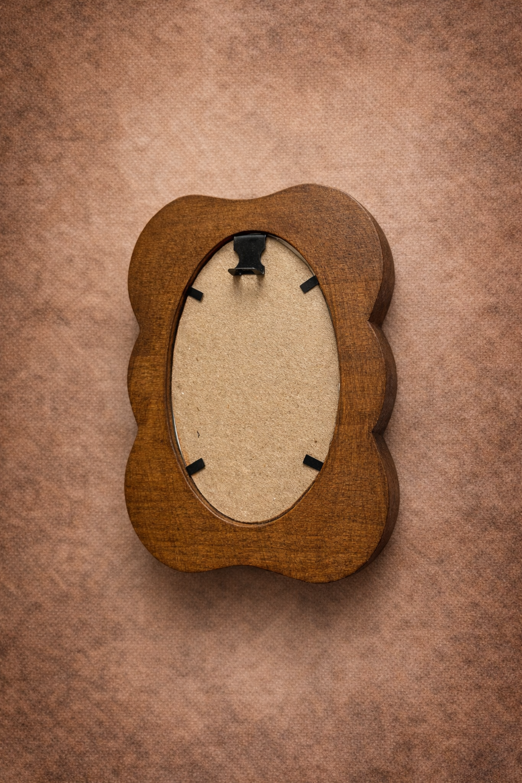 Wooden picture frame with an oval cutout on a brown textured background