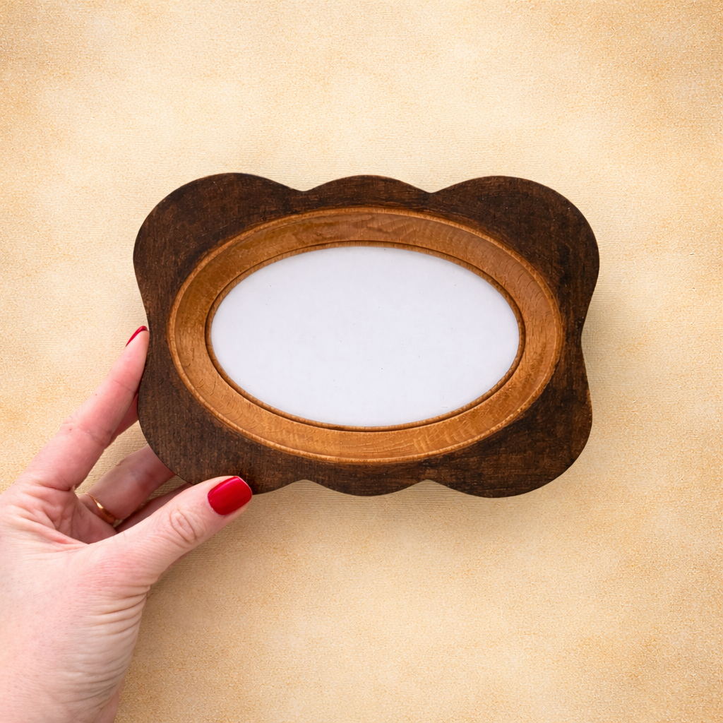 Wooden frame held by a hand on a beige background