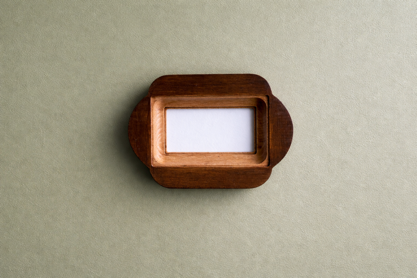 Wooden photo frame with a white card inside on a beige background