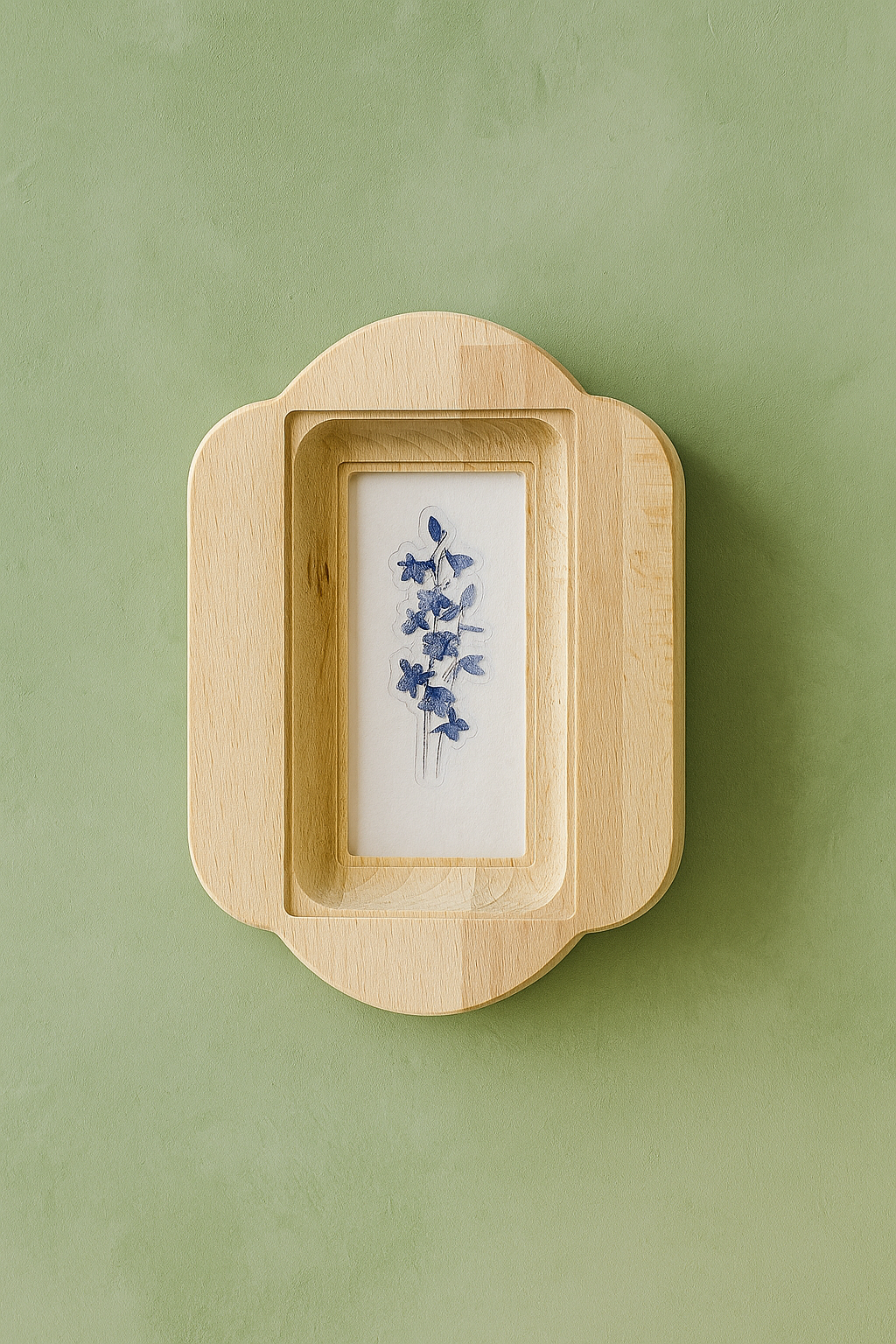 Wooden frame with a small painting of blue flowers on a green background