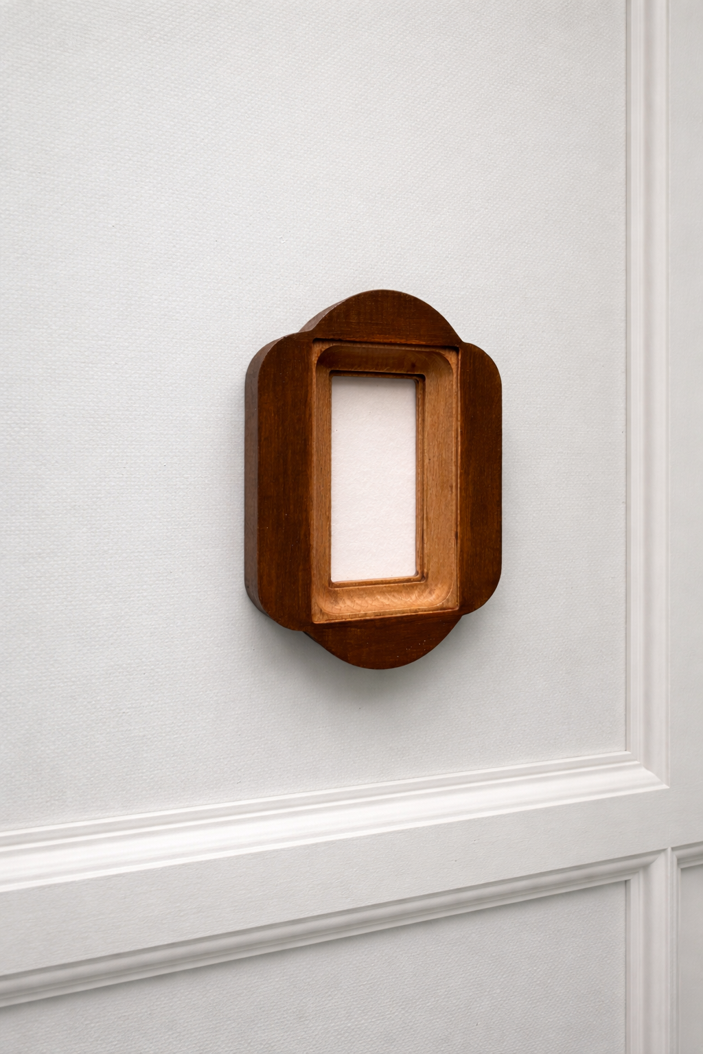 Wooden picture frame on a white paneled wall