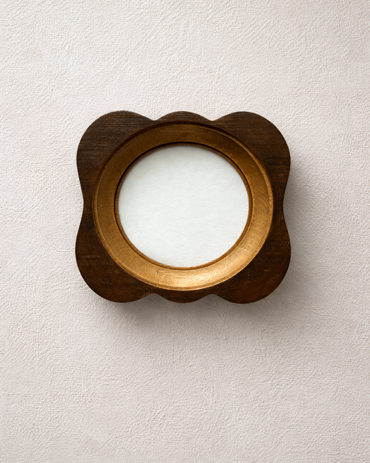 Wooden circular frame with a white center on a beige background