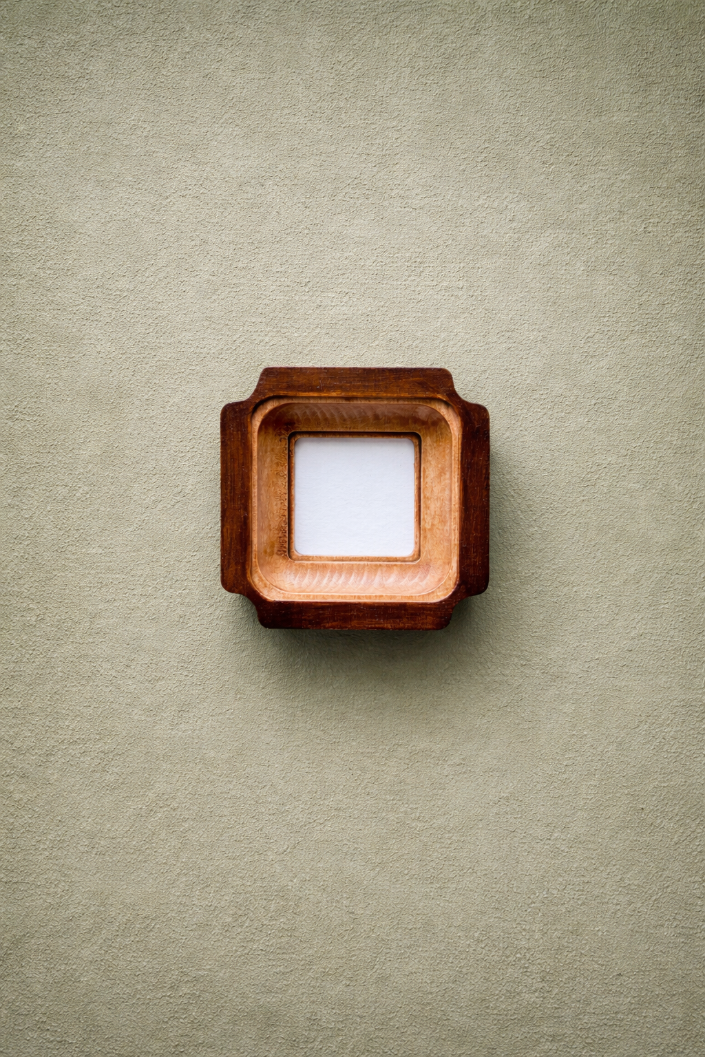 Wooden picture frame on a textured beige wall