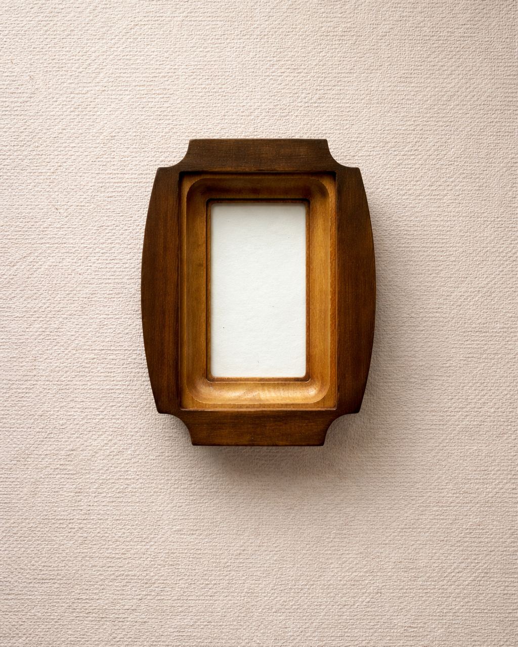 Wooden picture frame on a textured beige wall