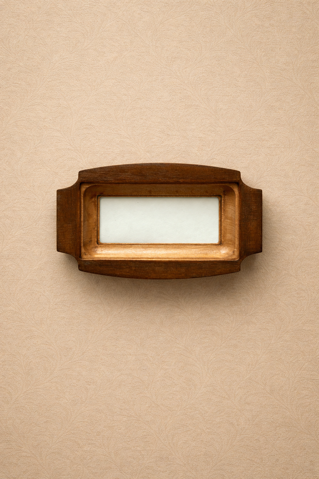Wooden photo frame on a beige wall