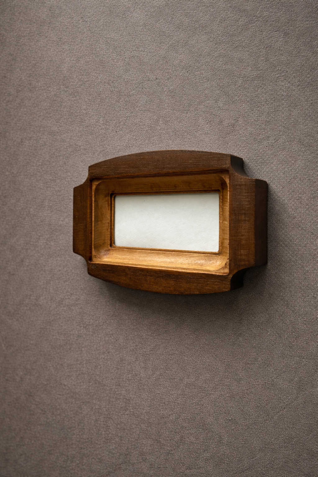 Wooden handmade picture frame on a gray wall